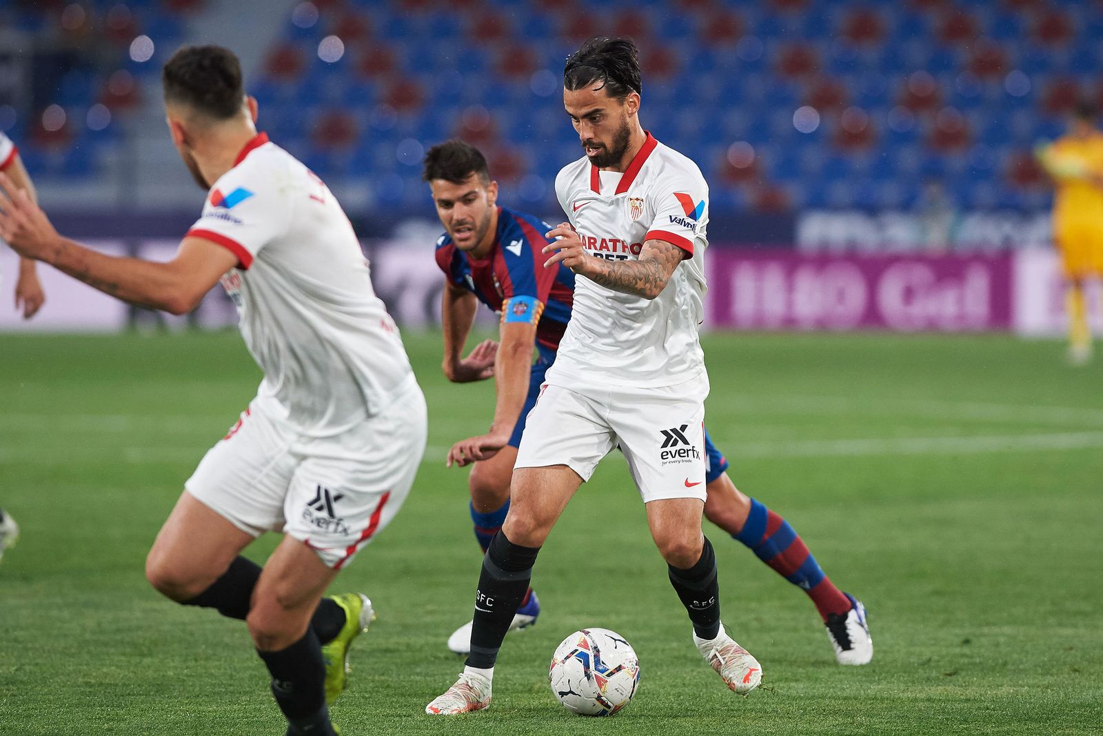 Suso aguanta el balón mientras Ocampos espera el pase.