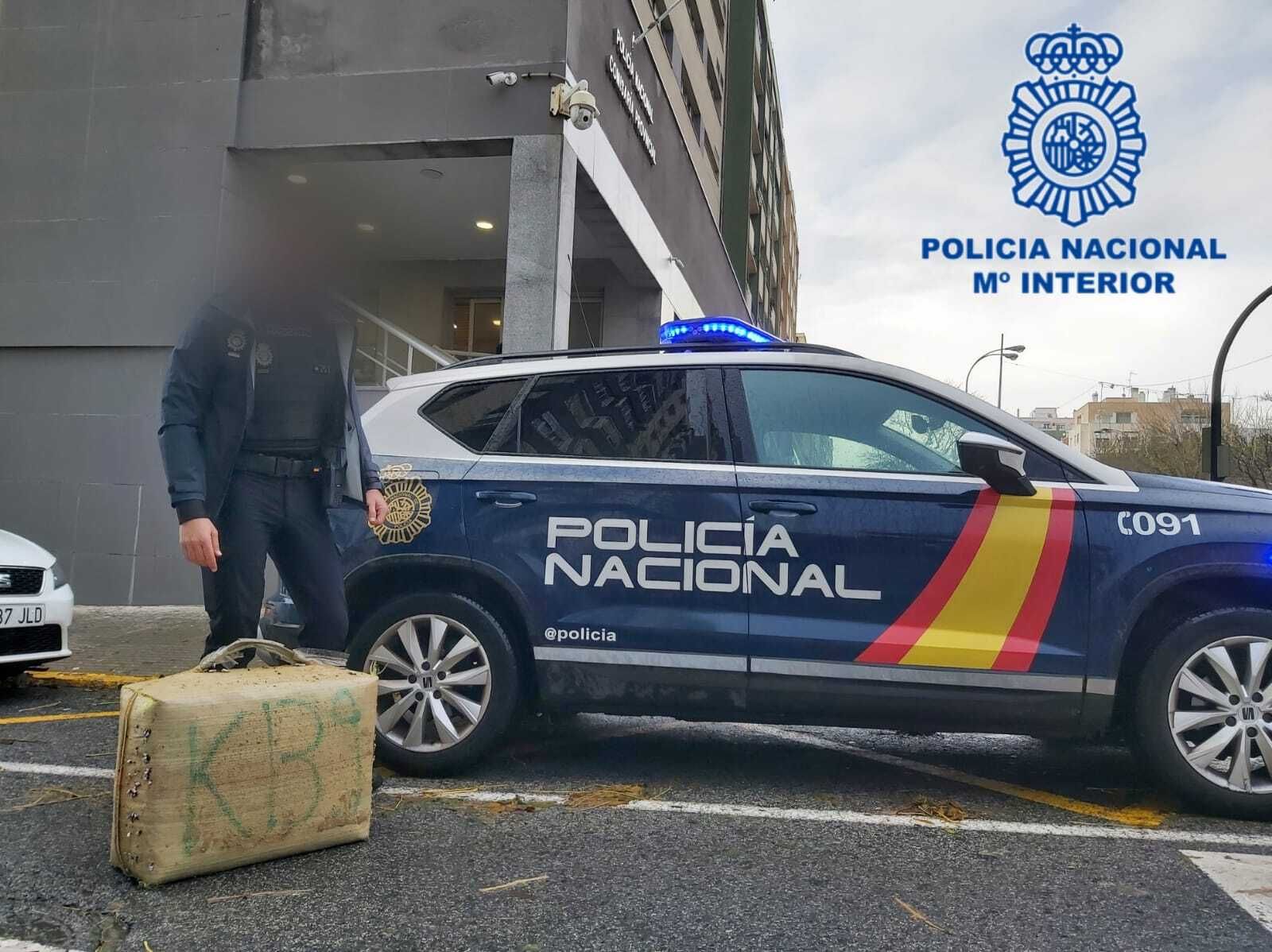 Un agente de la Policía Nacional custodia el fardo hallado en la playa de Santa María del Mar.