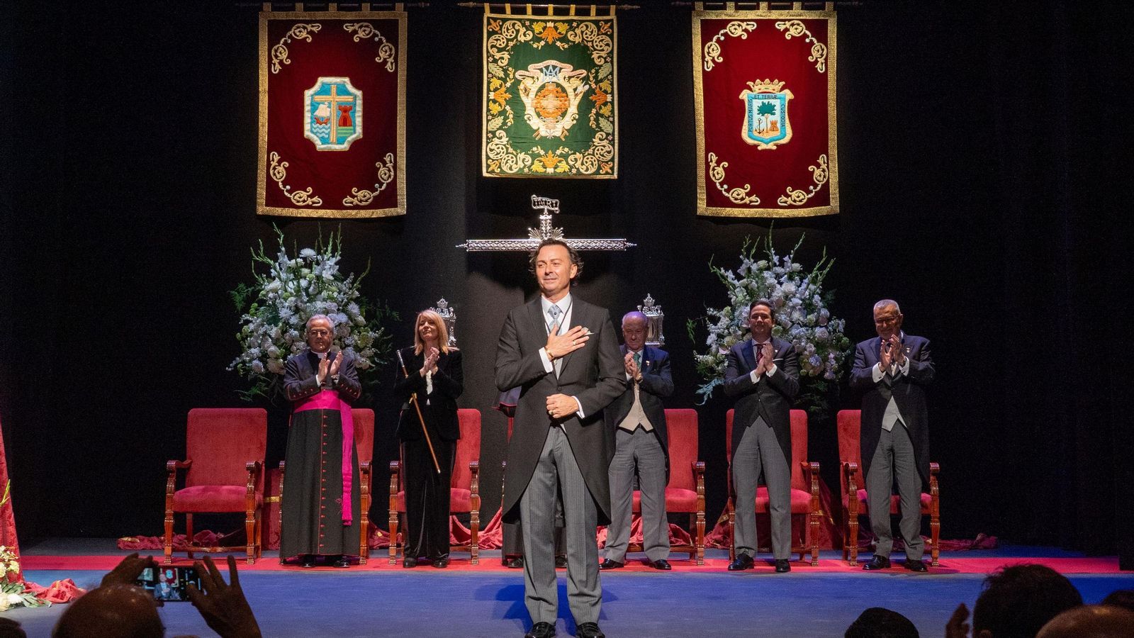 Fernando Romero en el centro del escenario, con todo el público en pie.