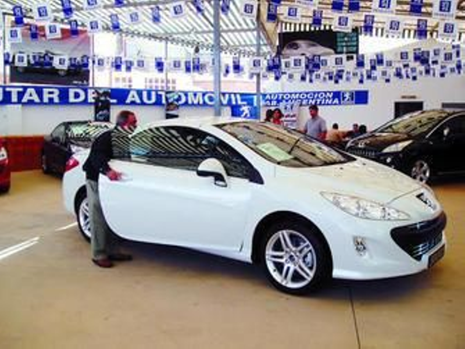 Un hombre comprueba uno de los modelos expuestos en la Feria del Transporte de Lucena.