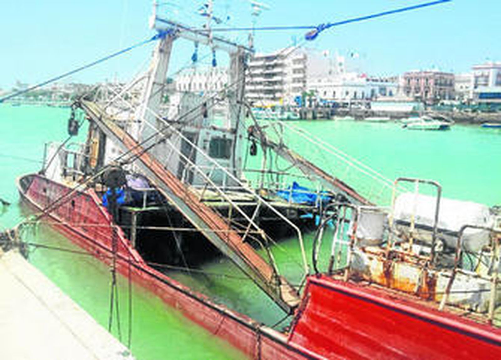 Uno de los barcos semihundidos, amarrado al muelle del río Guadalete.