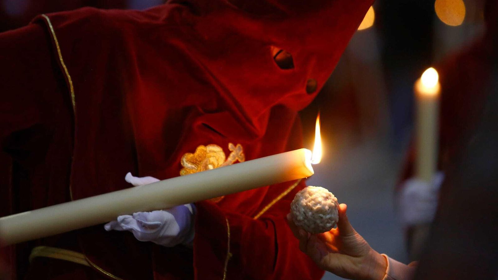 Un nazareno de Zamarrilla echa cera de su vela a una bola.