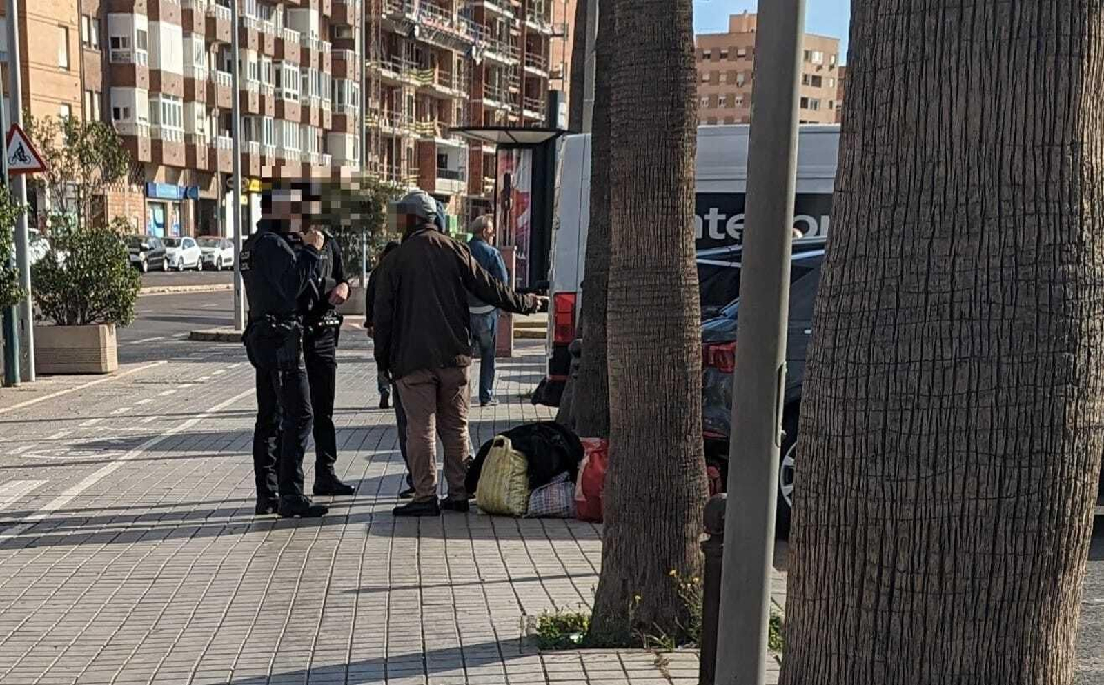 Dos agentes de la Policía Local de Almería junto a una persona que porta bolsas de viaje junto a la estación Intermodal.