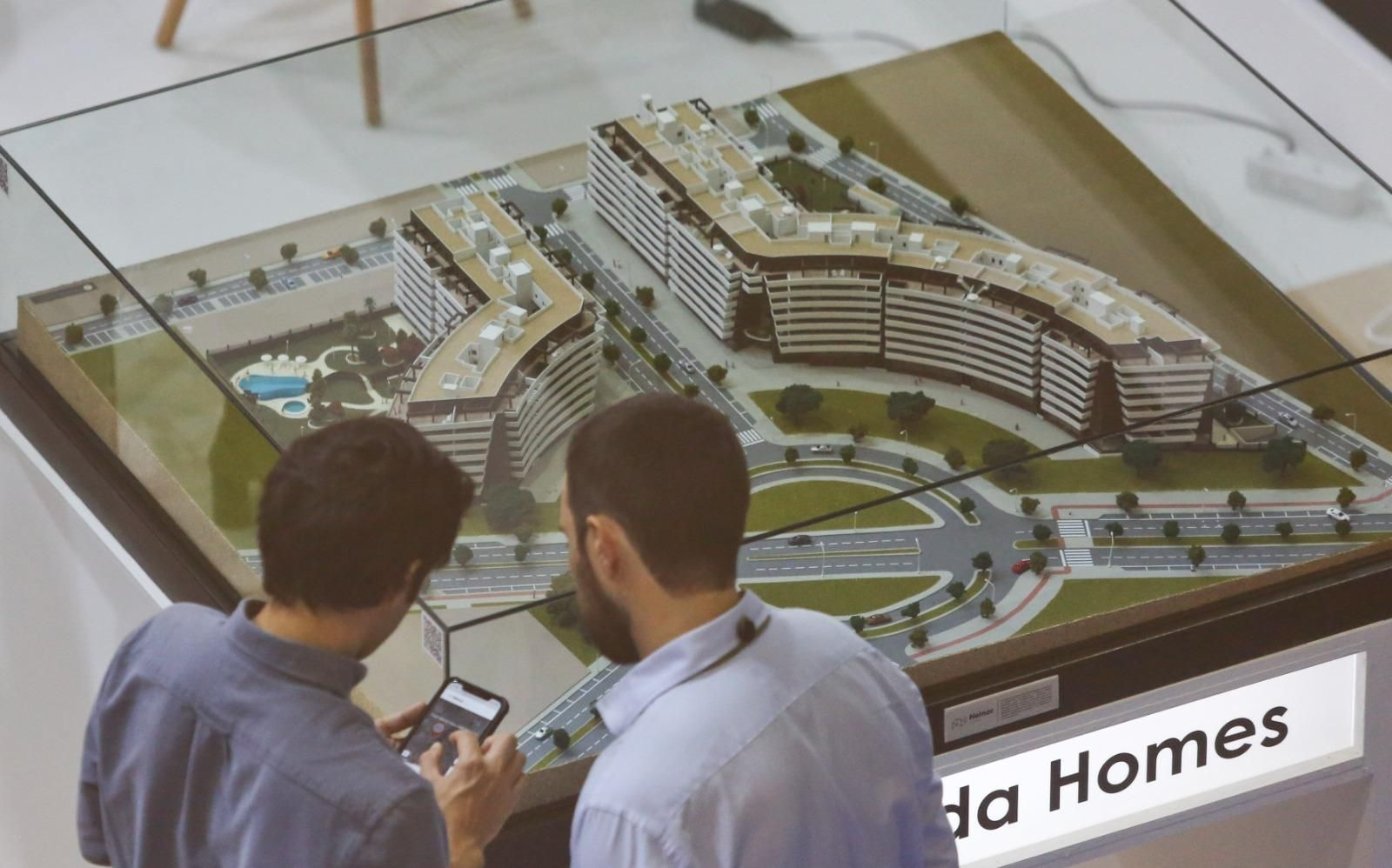 Compradores ante la publicidad de un promoción de viviendas.