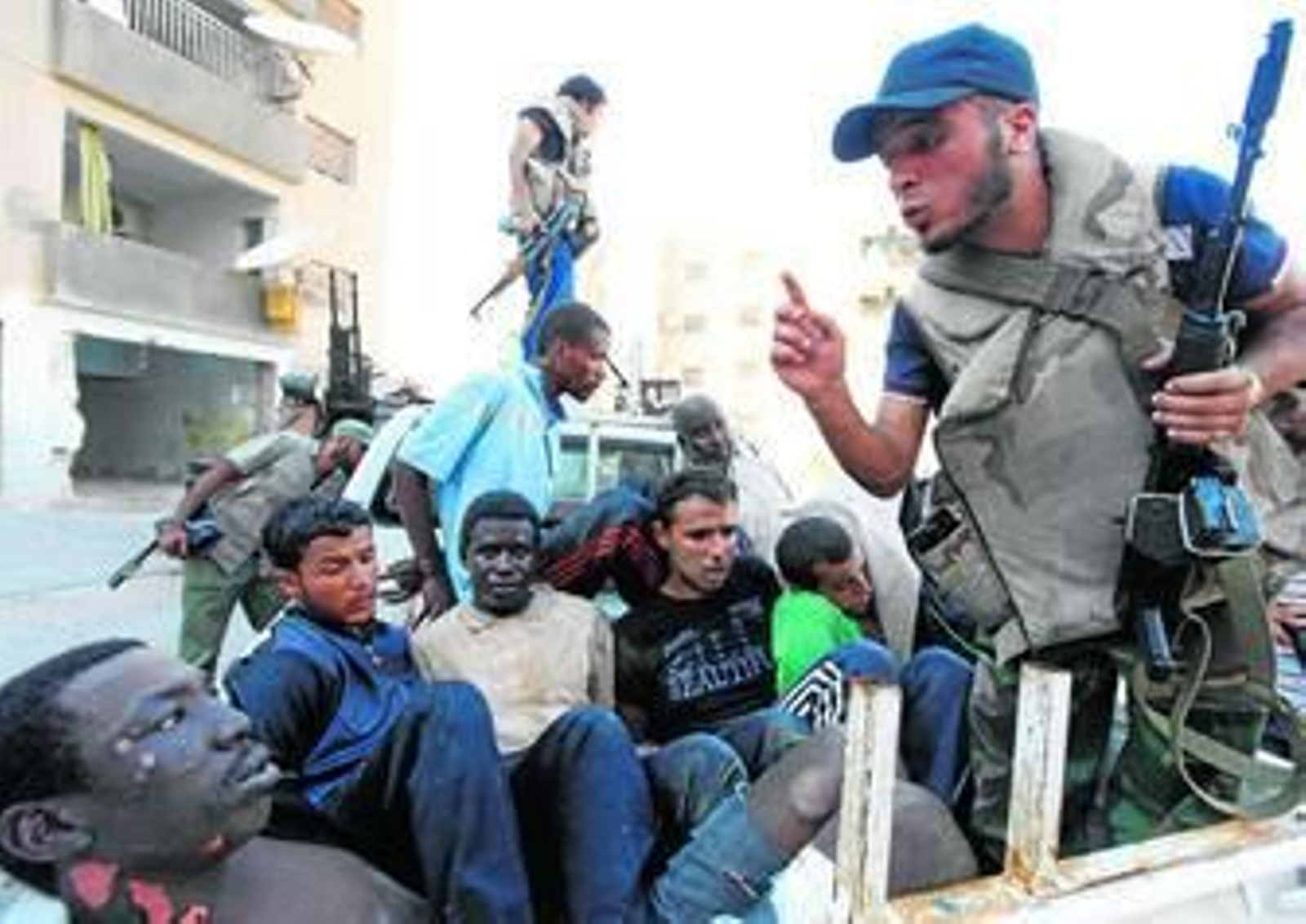 Combatientes rebeldes vigilan a los detenidos tras el combate con las fuerzas de Gadafi en el barrio Abu Salim de Trípoli.