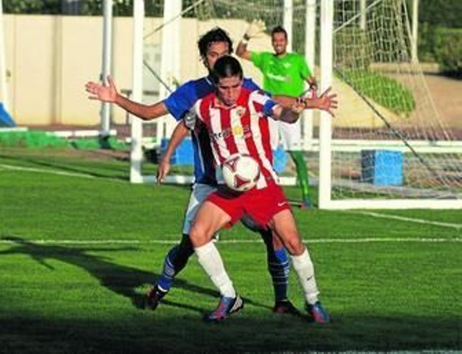 Cristóbal intenta marcharse con el esférico ante la presión de un rival durante un duelo en el anexo.