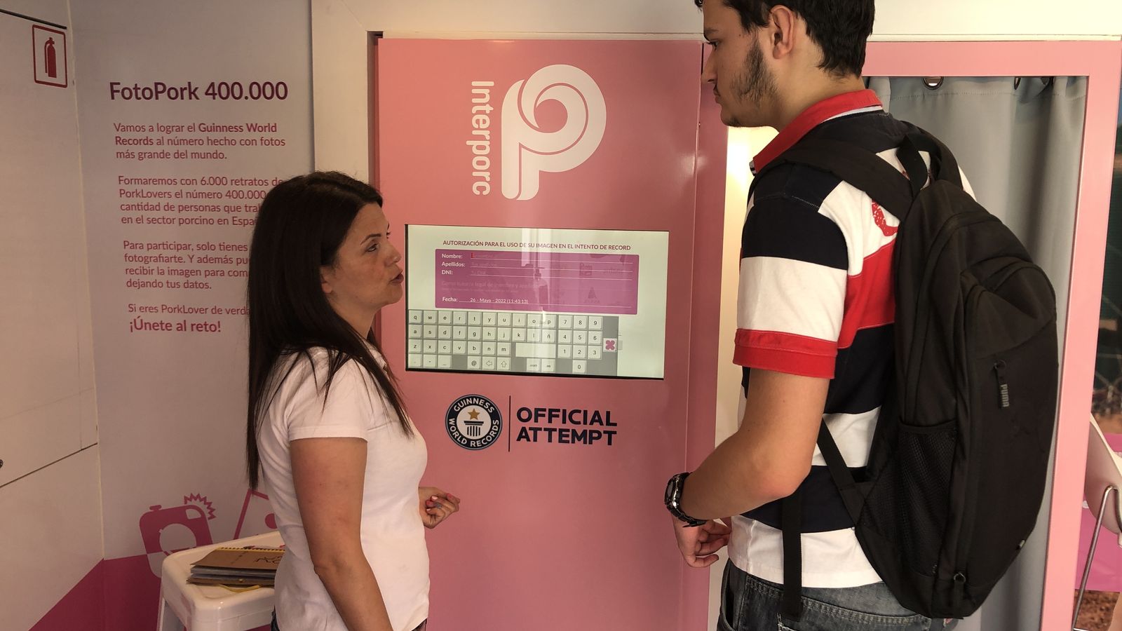 Una monitora le explica a un joven cómo hacerse una foto para el récord Guinness.