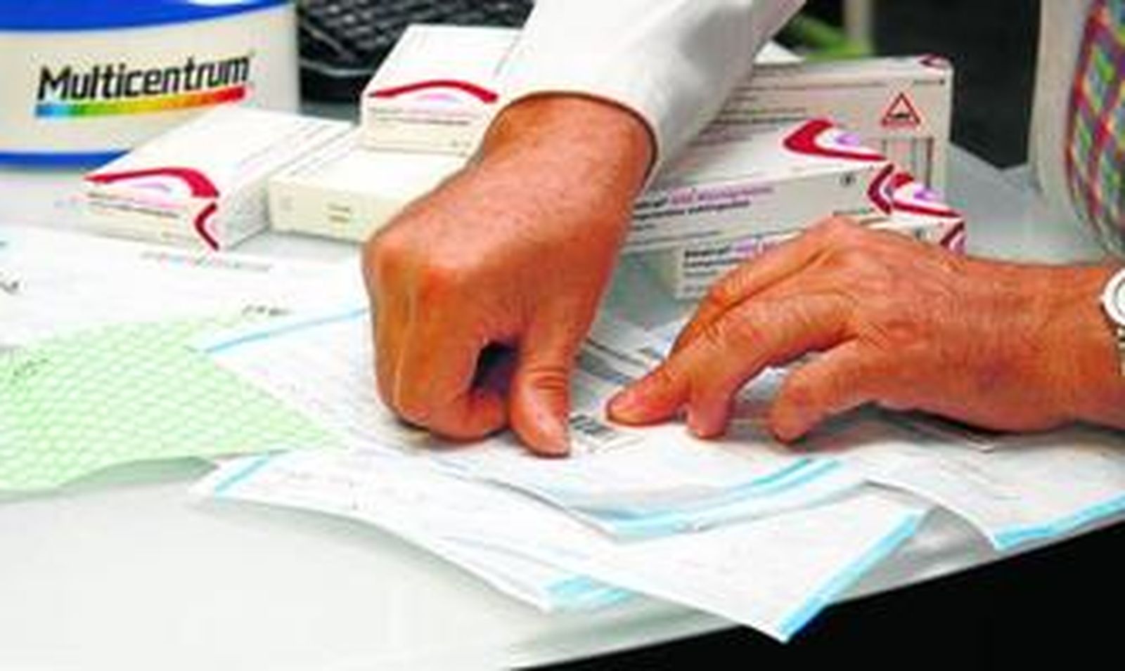 Un farmacéutico dispensa medicamentos a un usuario.