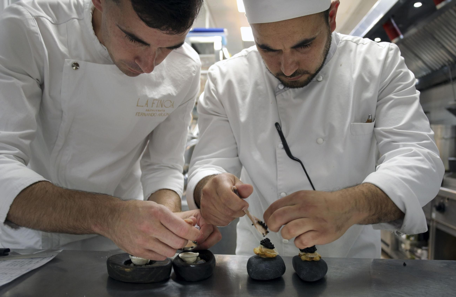Fernando Arjona prepara un plato con caviar de Riofrío junto a un ayudante.