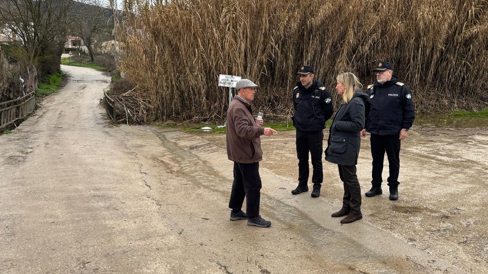 Policías informan del desalojo preventivo a los vecinos de Llano de la Cruz, en Ronda.