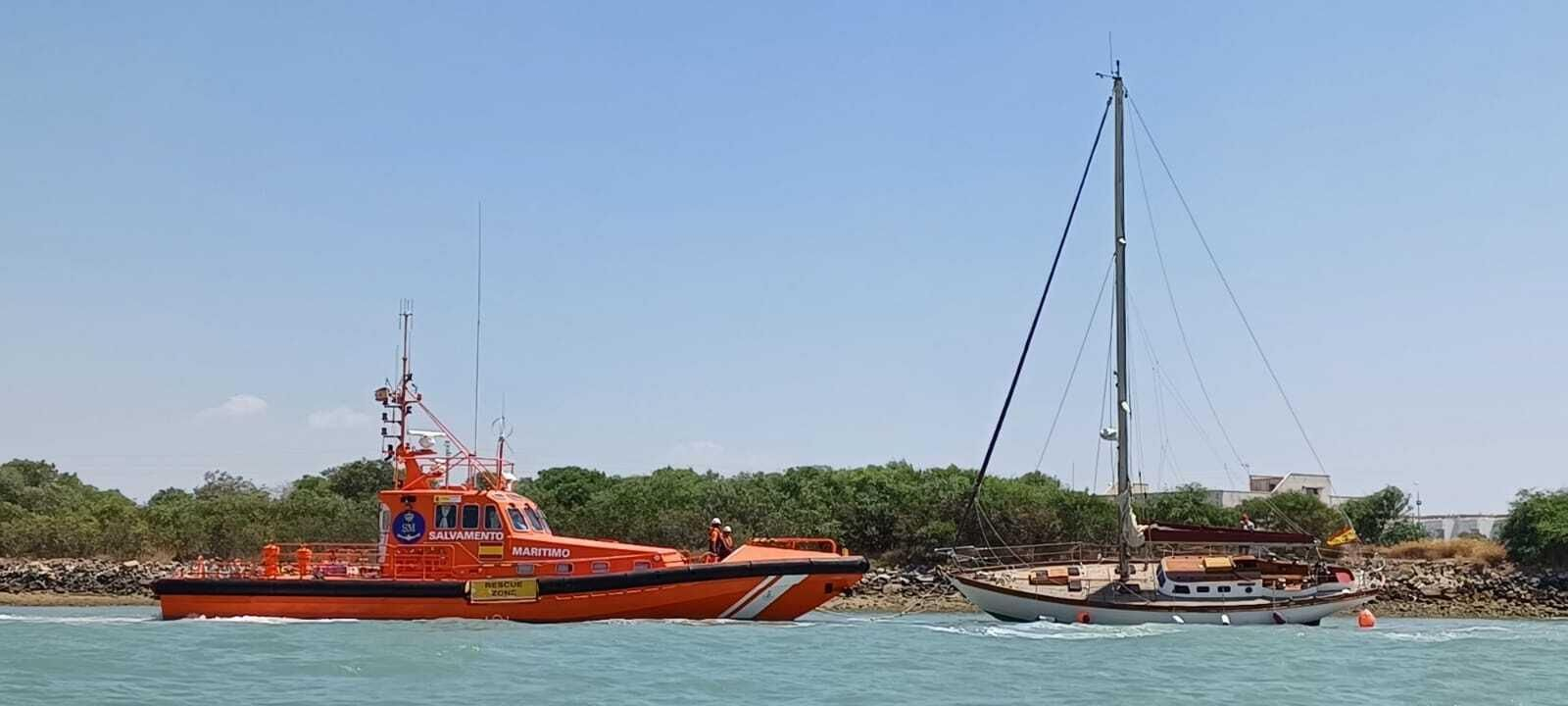 La embarcación de Salvamento Marítimo, con el  velero varado en el Guadalete.
