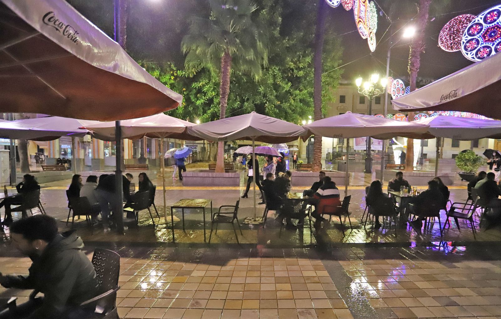 Establecimiento en la Plaza de las Monjas con la terraza abierta y con público bajo la lluvia sobre las siete y media de la tarde.