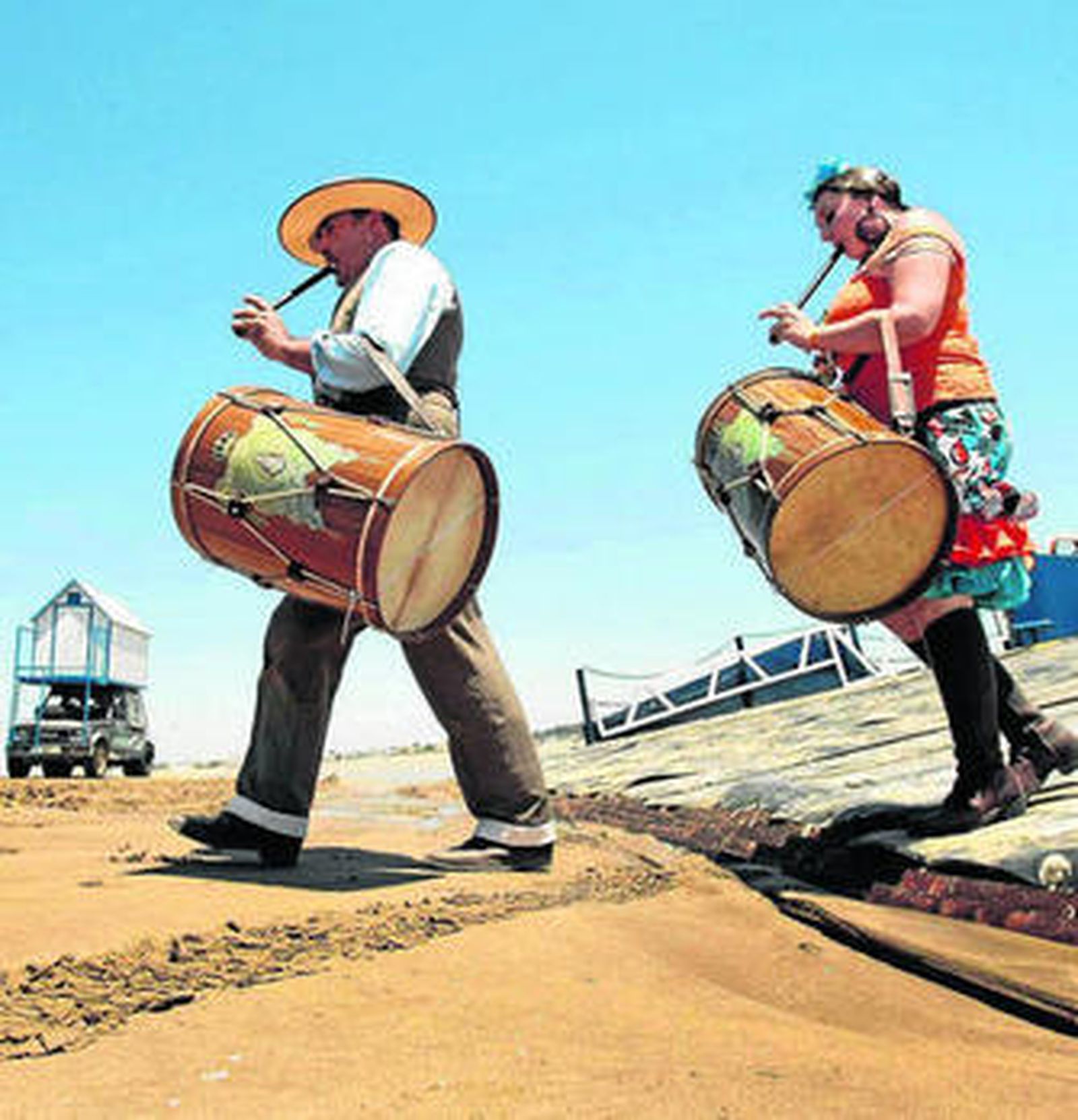 Dos romeros de Chipiona con pito y tambor bajando de la barcaza para iniciar el camino por Doñana.