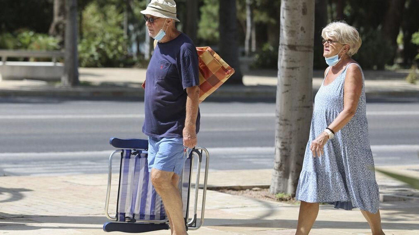 Dos personas caminan por el Paseo del Parque en Málaga capital.