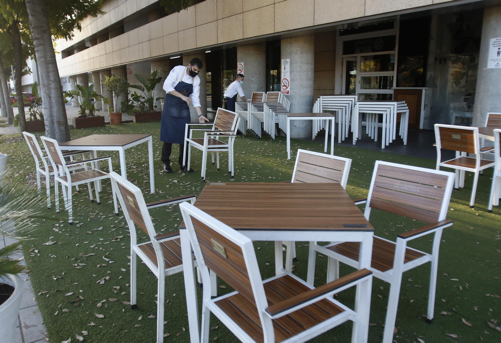 Camareros de un bar cierran una terraza en Córdoba tras el decreto de la Junta.