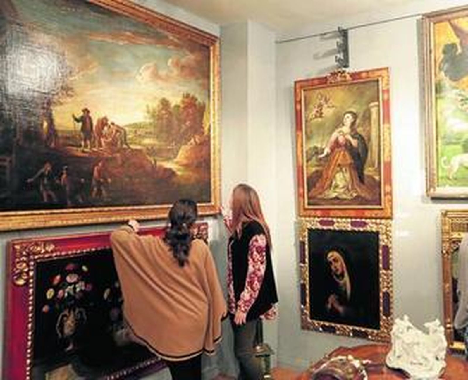 1. Dos mujeres contemplan el 'Paisaje fluvial con pescadores al atardecer', de David Teniers el Joven. 2. La guitarra de Antonio de Torres que sale a puja. 3. El 'San Juan Bautista en oración' de Juan van der Hamen, la pieza estrella de la cita.