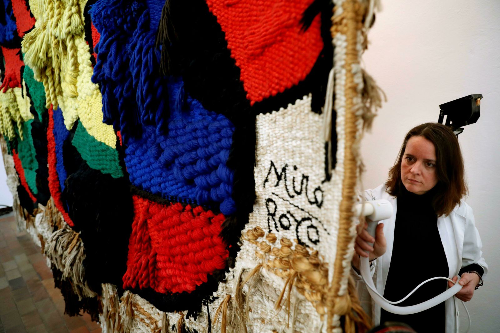 La restauradora de la Fundación Miro, Elisabet Serrat, trabajando en el dorso del tapiz.