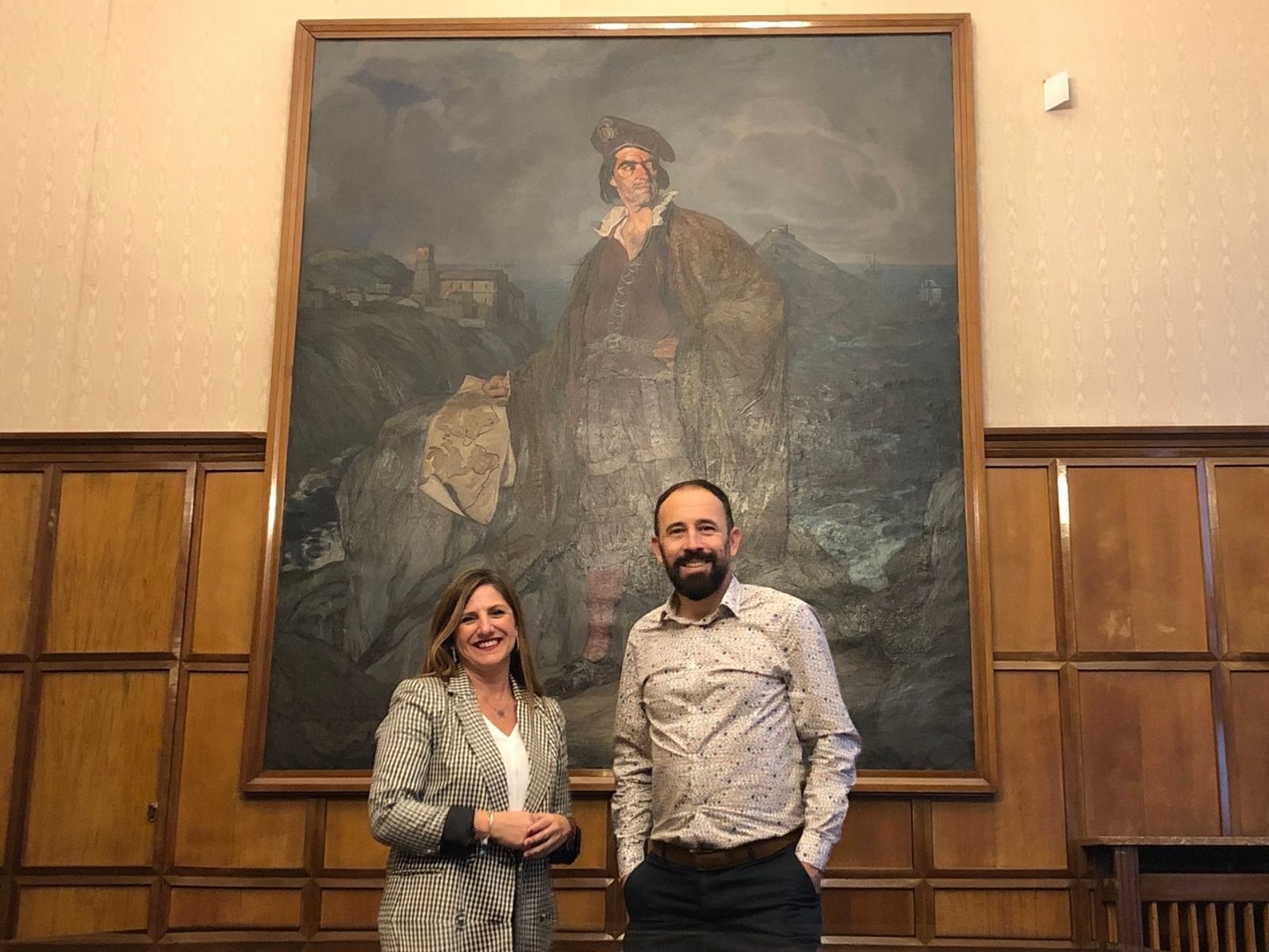 Irene García y Denis Itxaso, ante el retrato de Juan Sebastián Elcano pintado por Zuloaga que preside la Sala Elcano de la Diputación de Guipúzcoa