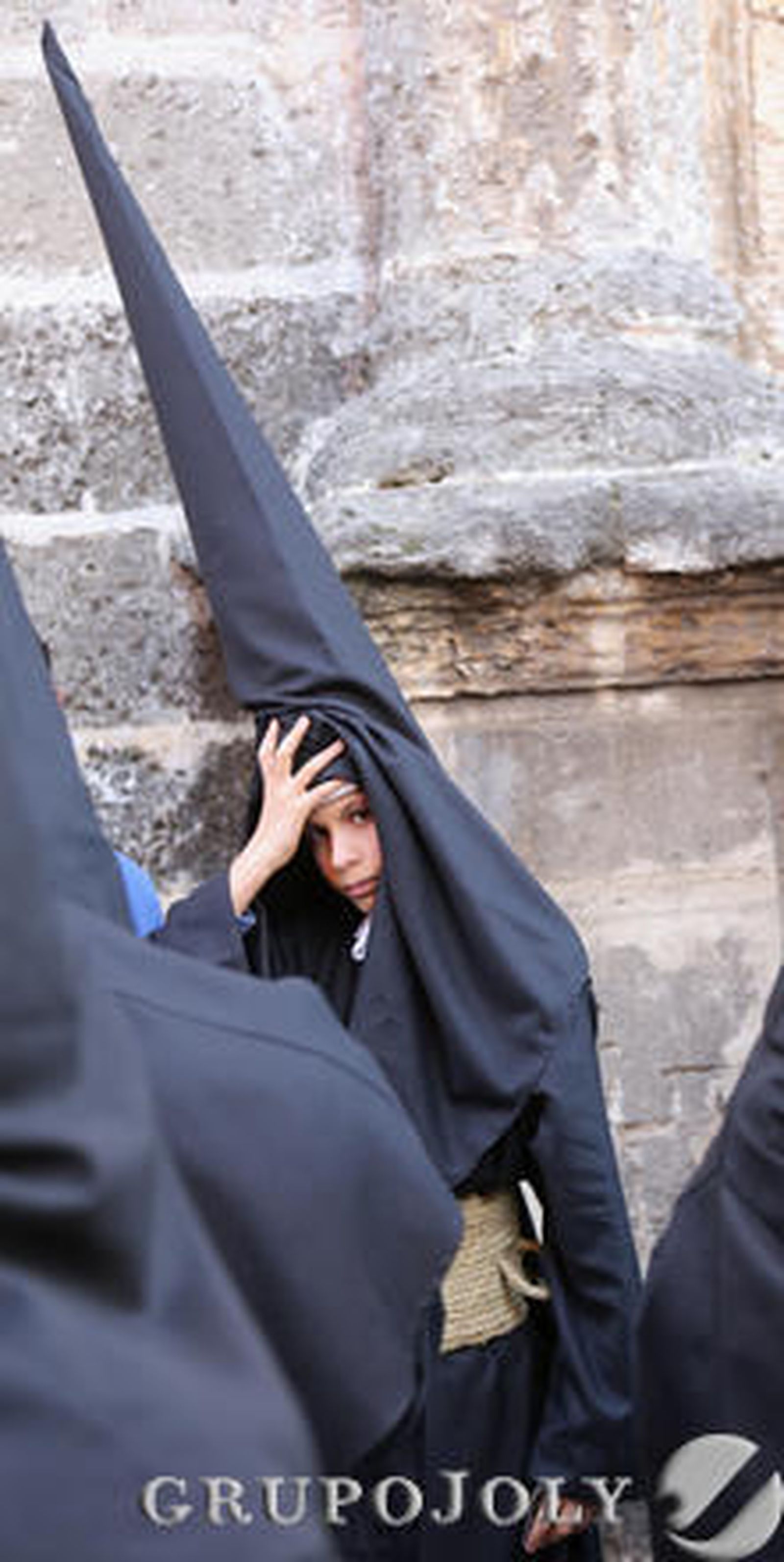 Un nazareno de la Hermandad de la Vera Cruz se levanta el capirote momentos antes de entrar en la iglesia de San Juan de los Caballeros.

Foto: Miguel Angel Gonzalez