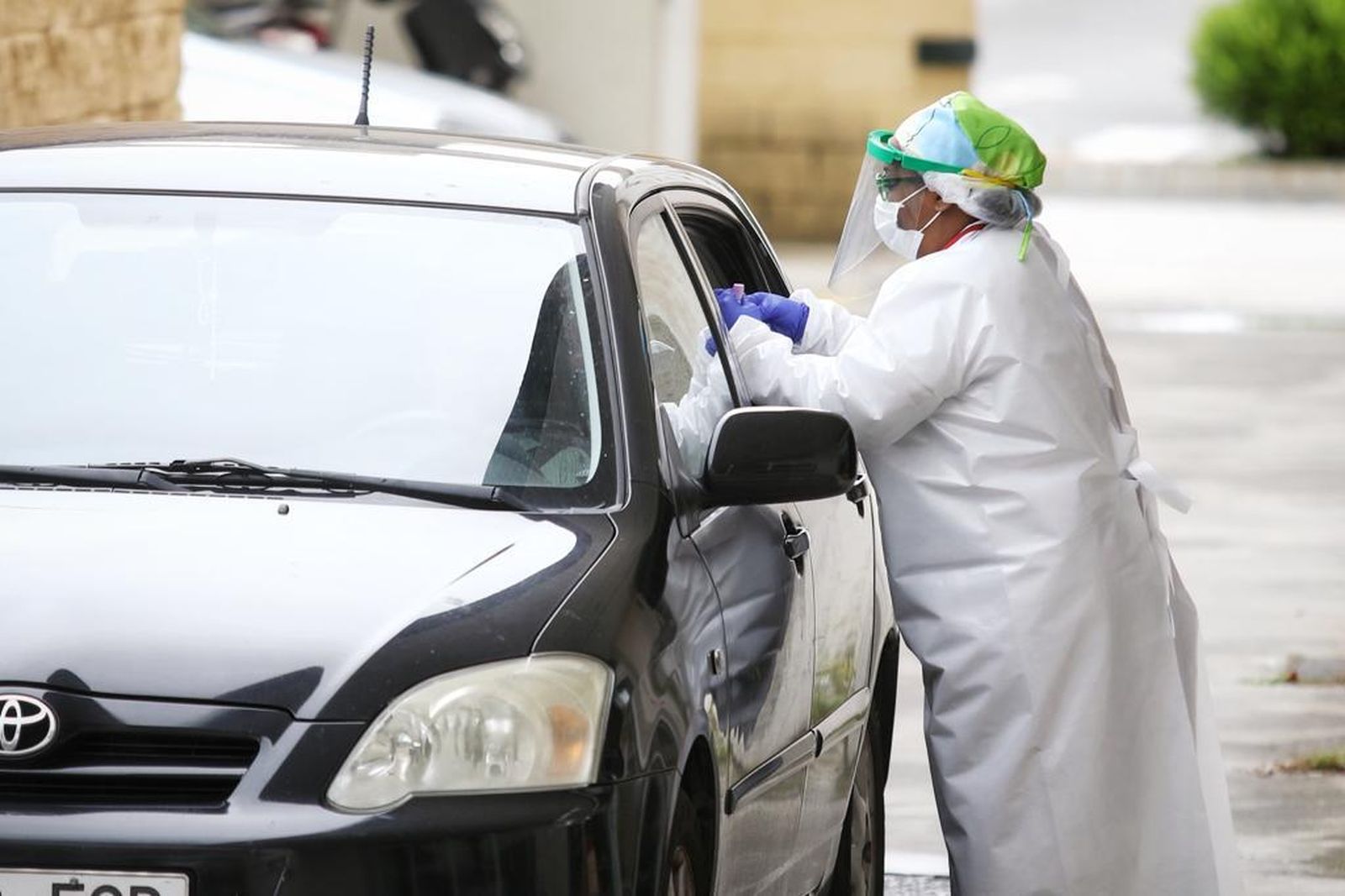 Un profesional toma muestras de un paciente sin que éste tenga que salir del vehículo en el centro de salud La Paz.