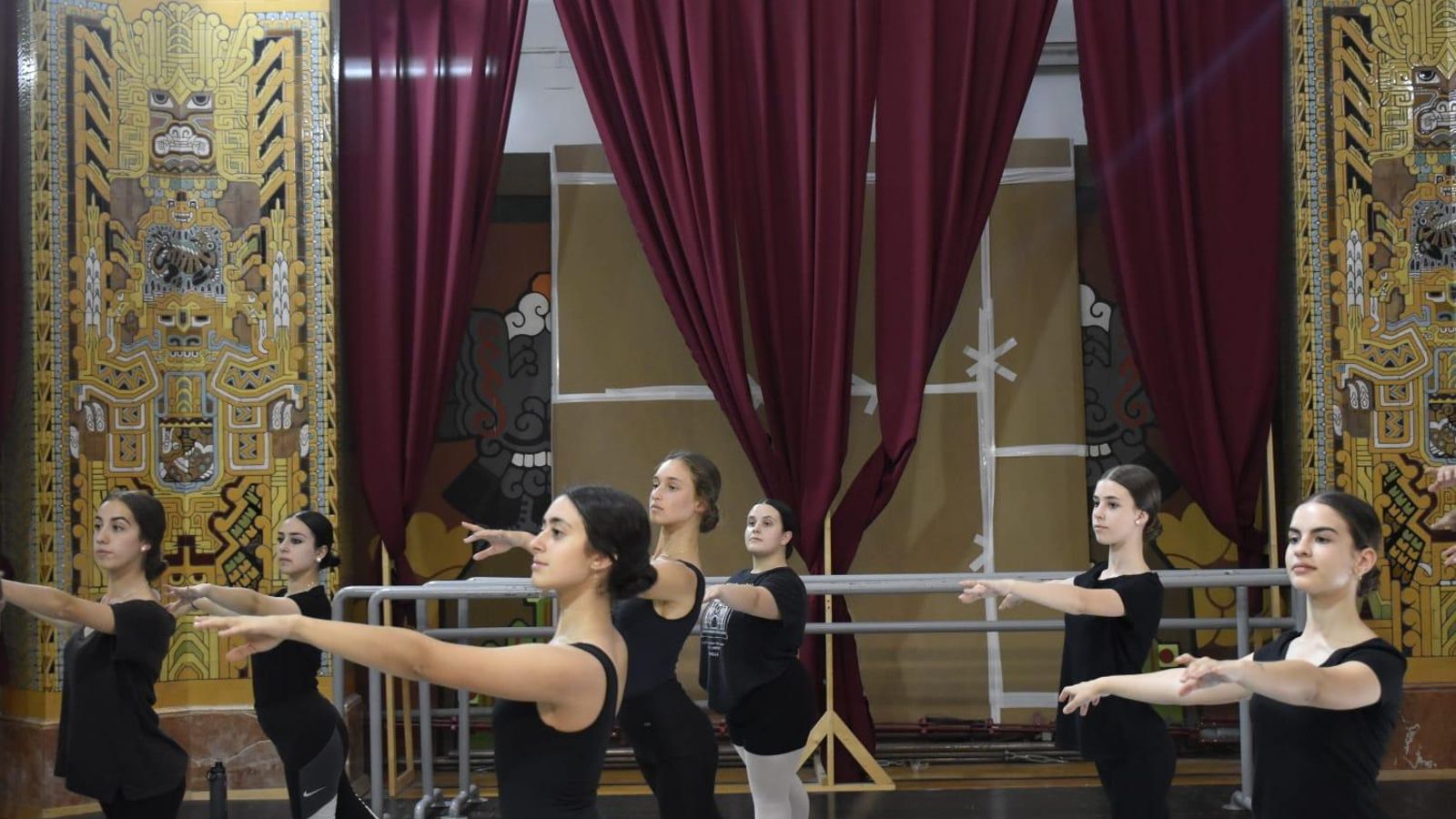 Clases de danza en una sala cubierta con cartones.