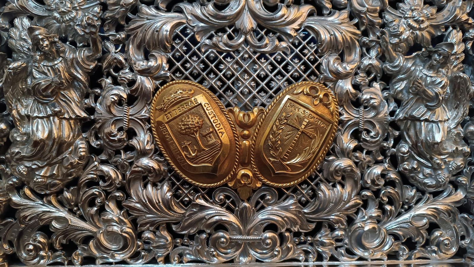 Los escudos de Huelva y San Sebastián, del Ayuntamiento y la parroquia, unidos en el respiradero del paso en el que procesiona.