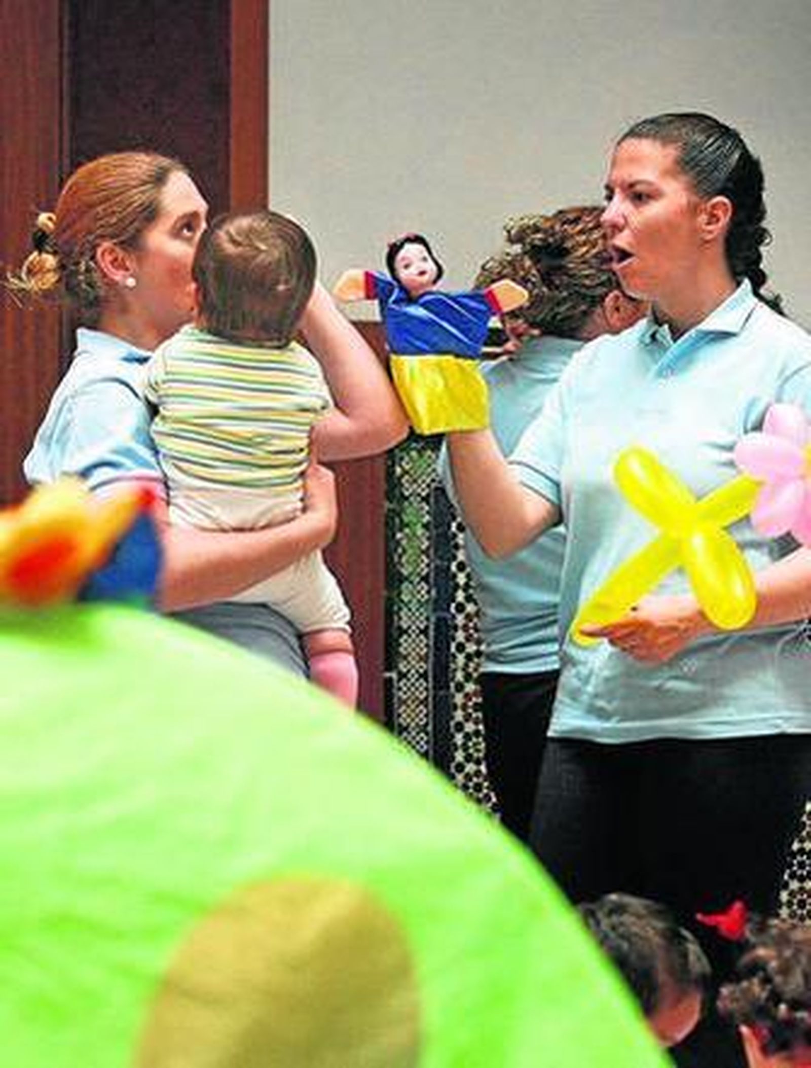 Monitoras jugando con un menor en un centro educativo.