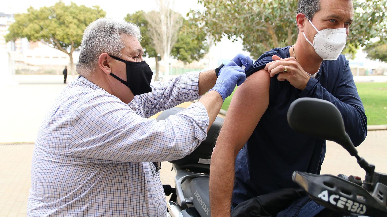 Uno de los agentes recibe la vacuna en su moto.