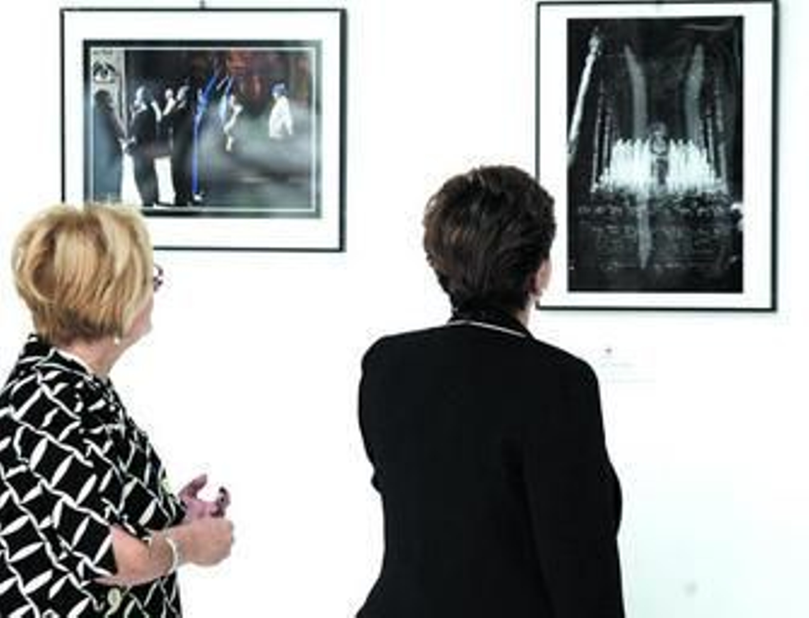 Dos mujeres observan algunas de las fotografías que integran la muestra.