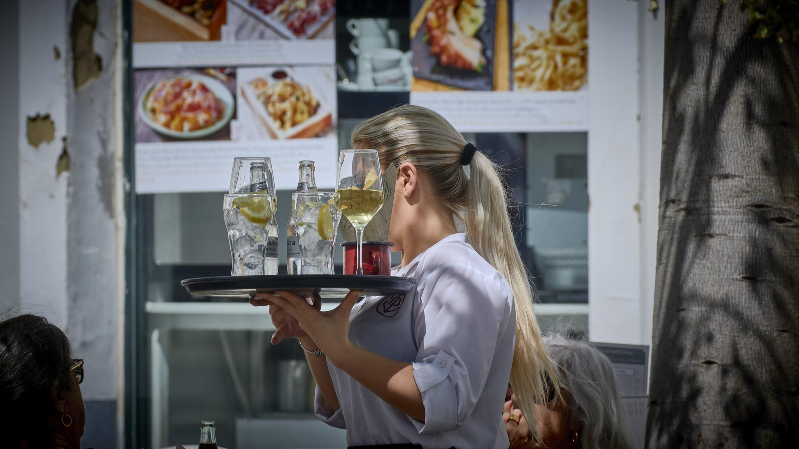 Una mujer trabajando como camarera en un bar de la ciudad.