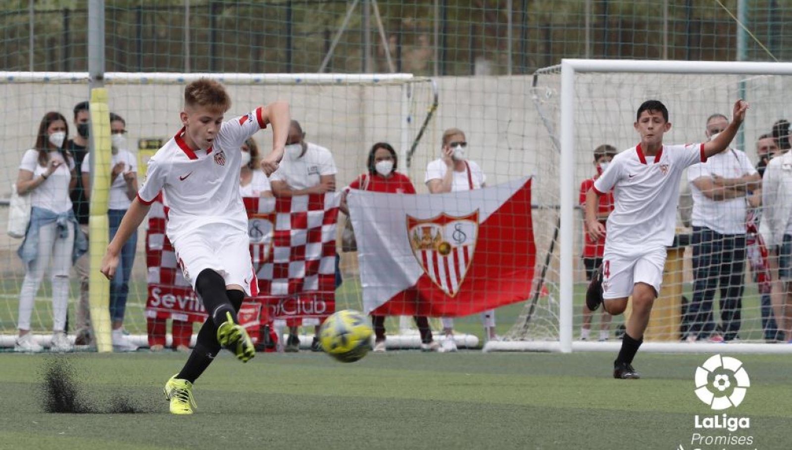 Un alevín del Sevilla busca a  un compañero desde posiciones retrasadas.