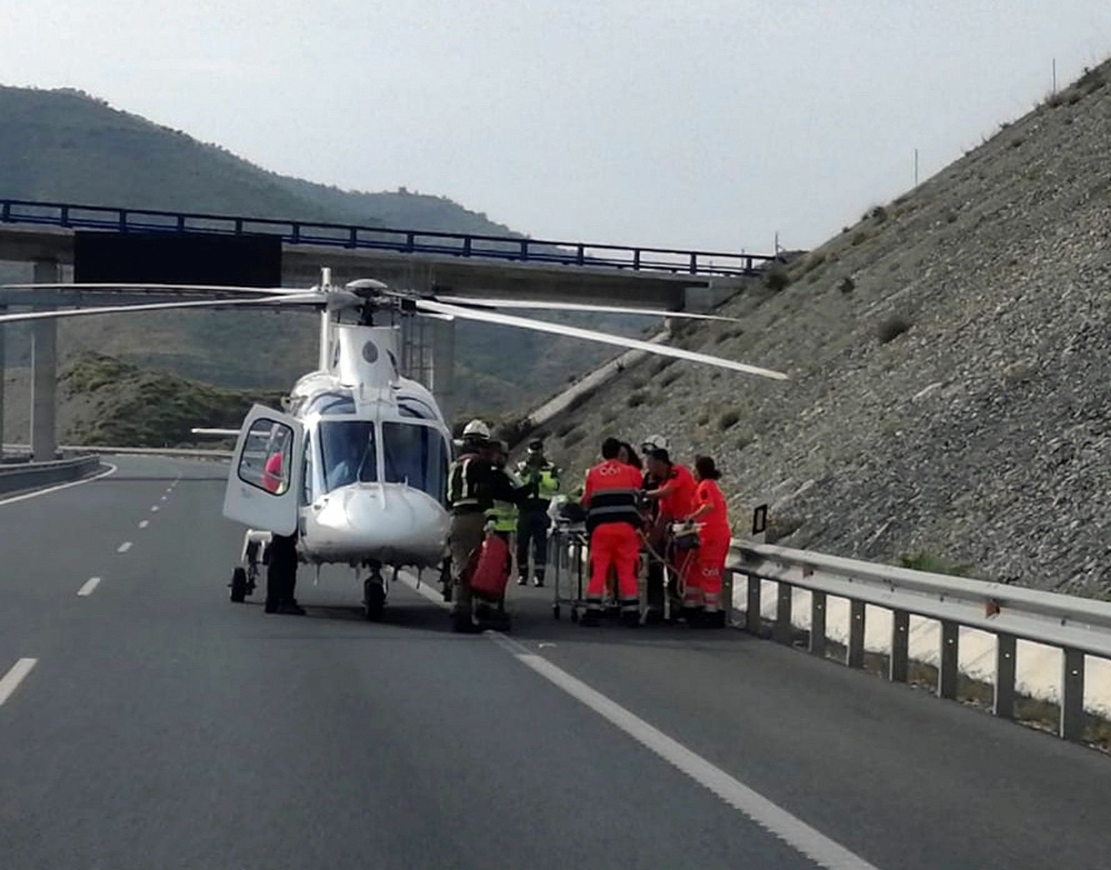 Personal sanitario evacúa del lugar del accidente a una de las heridas