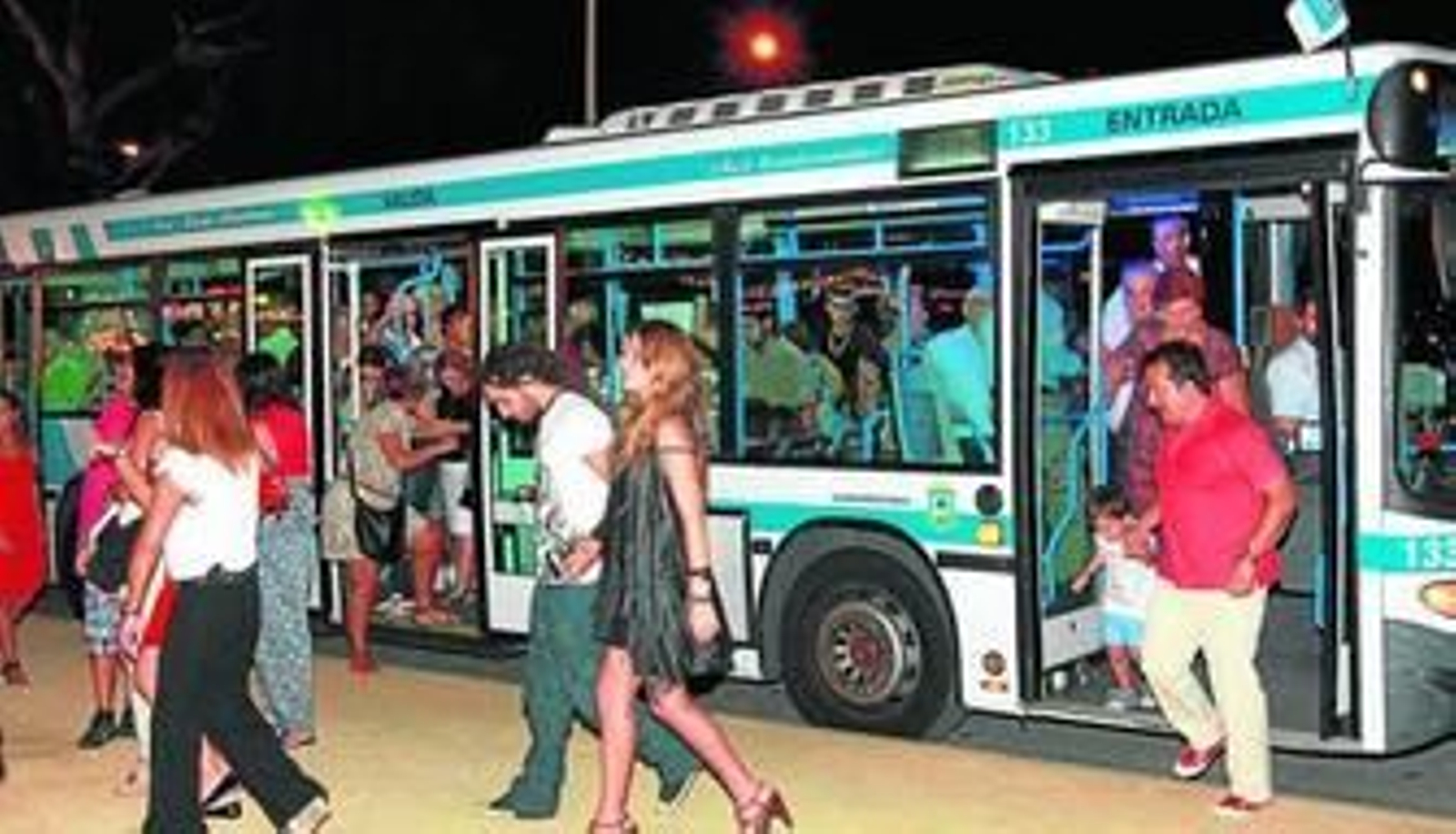 1. Feriantes vestidos para la ocasión bajan del abarrotado autobús frente a la portada 2. Un grupo de taxistas charla a la espera de pasajeros frente al recinto ferial. 3. Una multitud de onubenses se toman un refrigerio la noche del viernes en la feria 4. Un autocar de excursionistas se detiene junto a la parada de autobuses en las Colombinas. 5. Vistas en la noche del viernes.