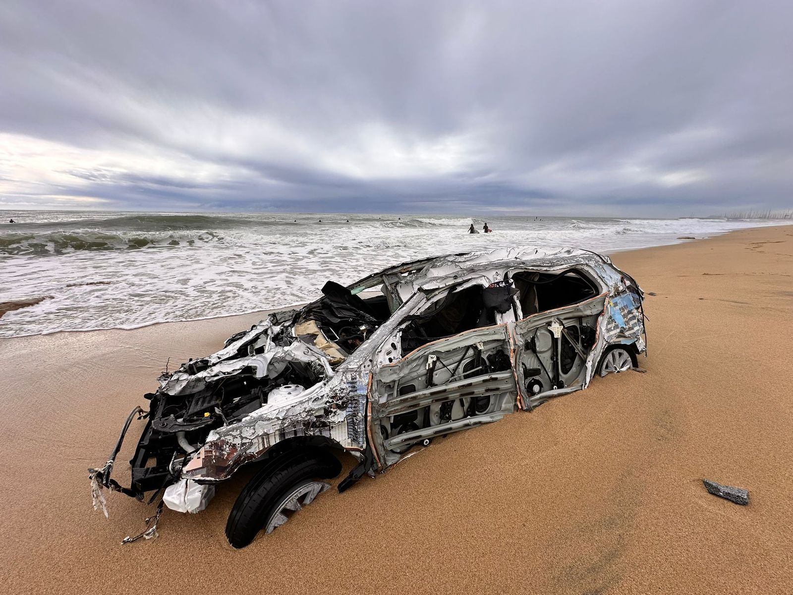 El coche varado en orilla de una playa de Barcelona.