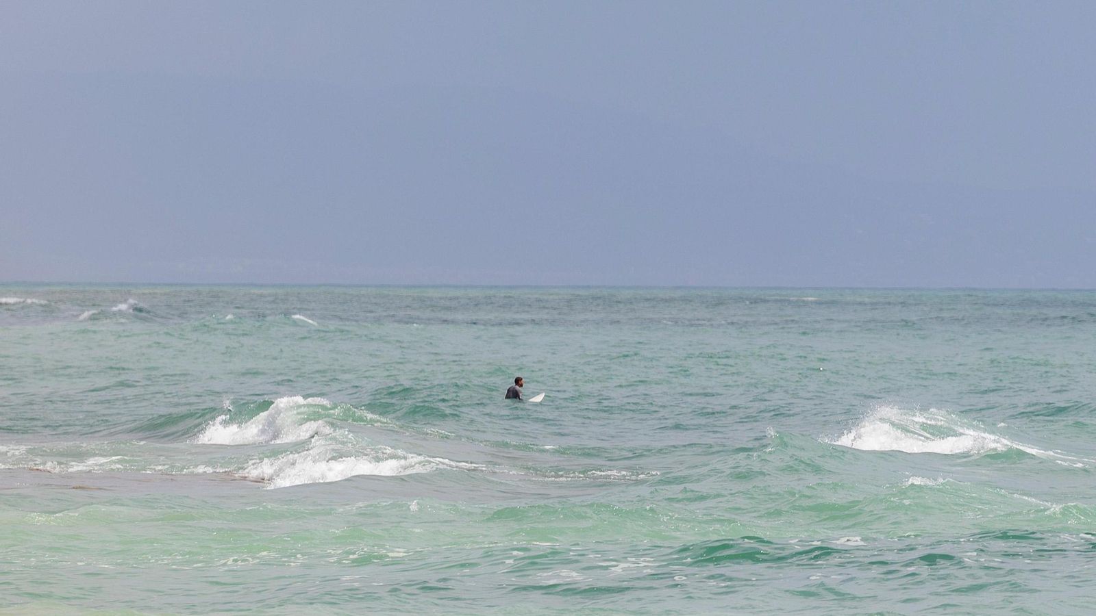 Imagen de un surfista en la playa de El Pirata a pesar de la prohibición.