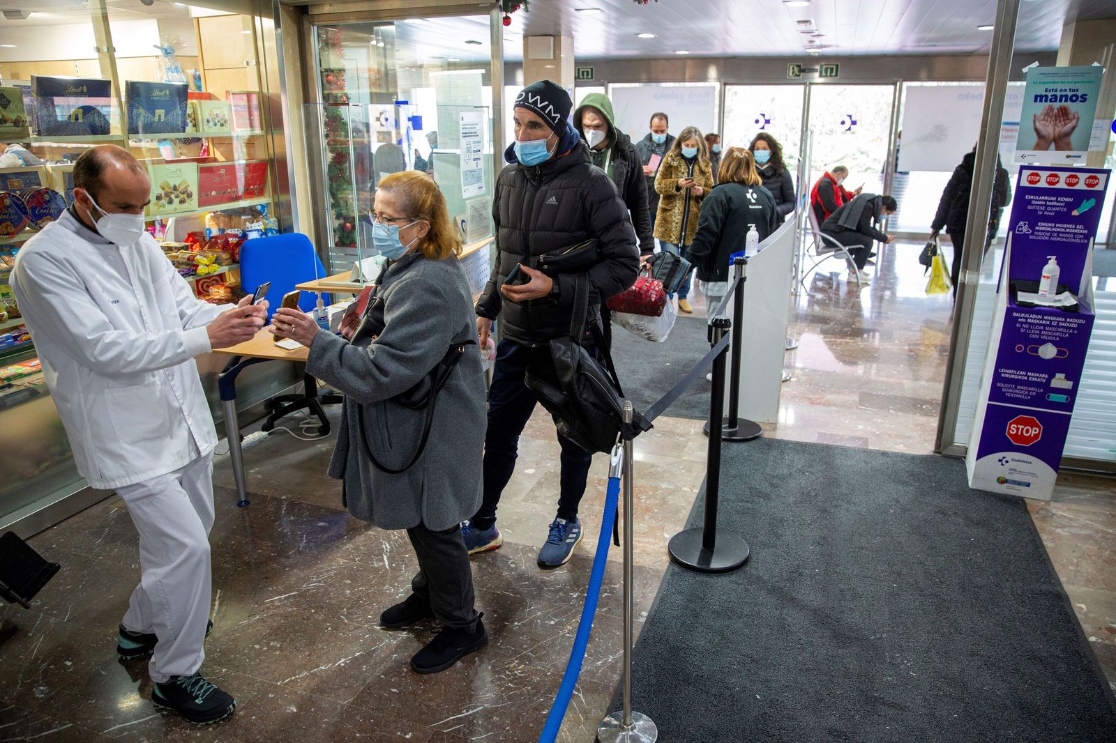 Varias personas preparan el pasaporte covid para entrar en un centro de salud del País Vasco