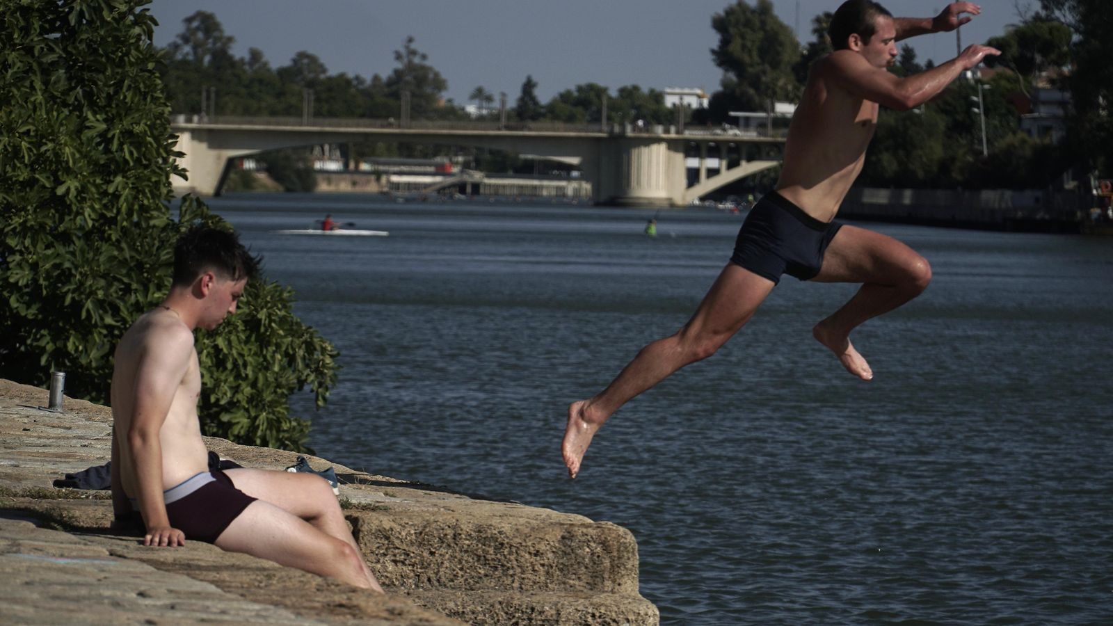 Unos jóvenes se bañan en el Río Guadalquivir para combatir el calor