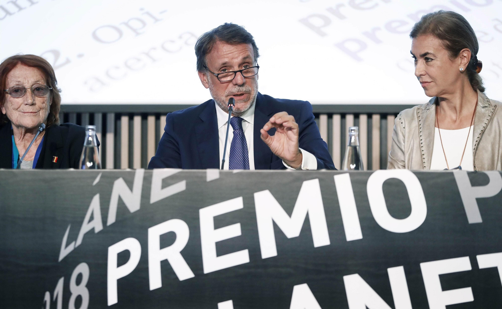 El presidente de la editorial Planeta, José Creuheras, flanqueado por las escritoras Carmen Posadas (d)  y Rosa Regás (i).