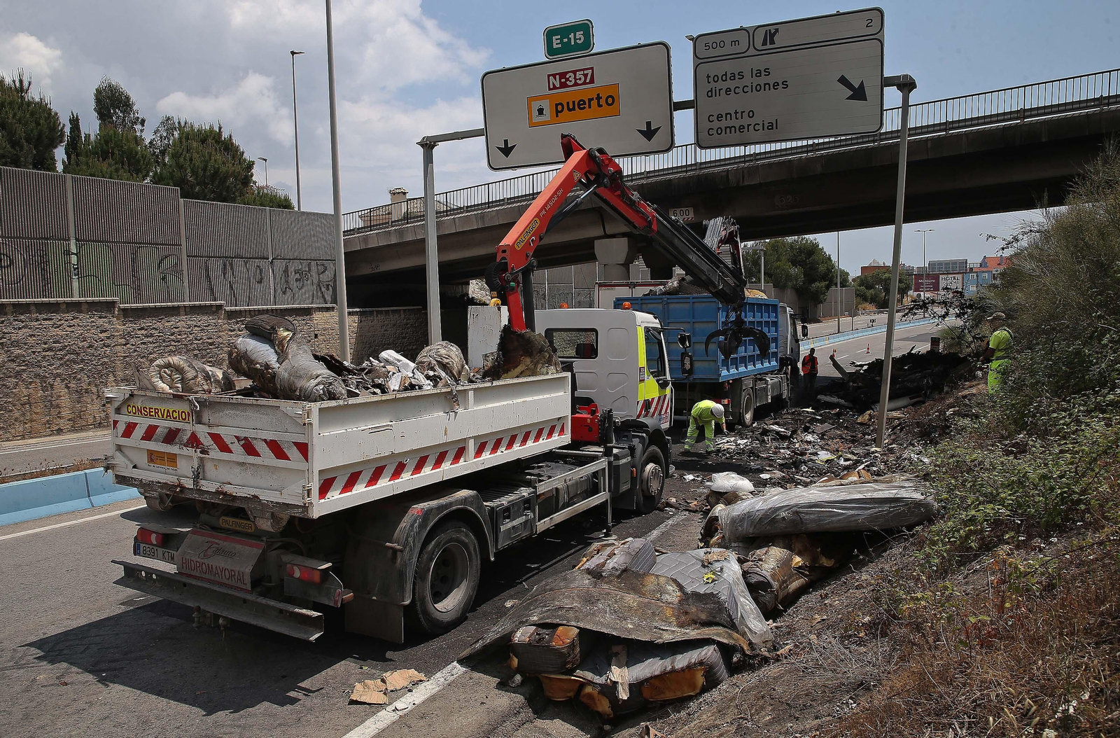 Fotos de la retirada de la carga del camión incendiado en el acceso norte de Algeciras