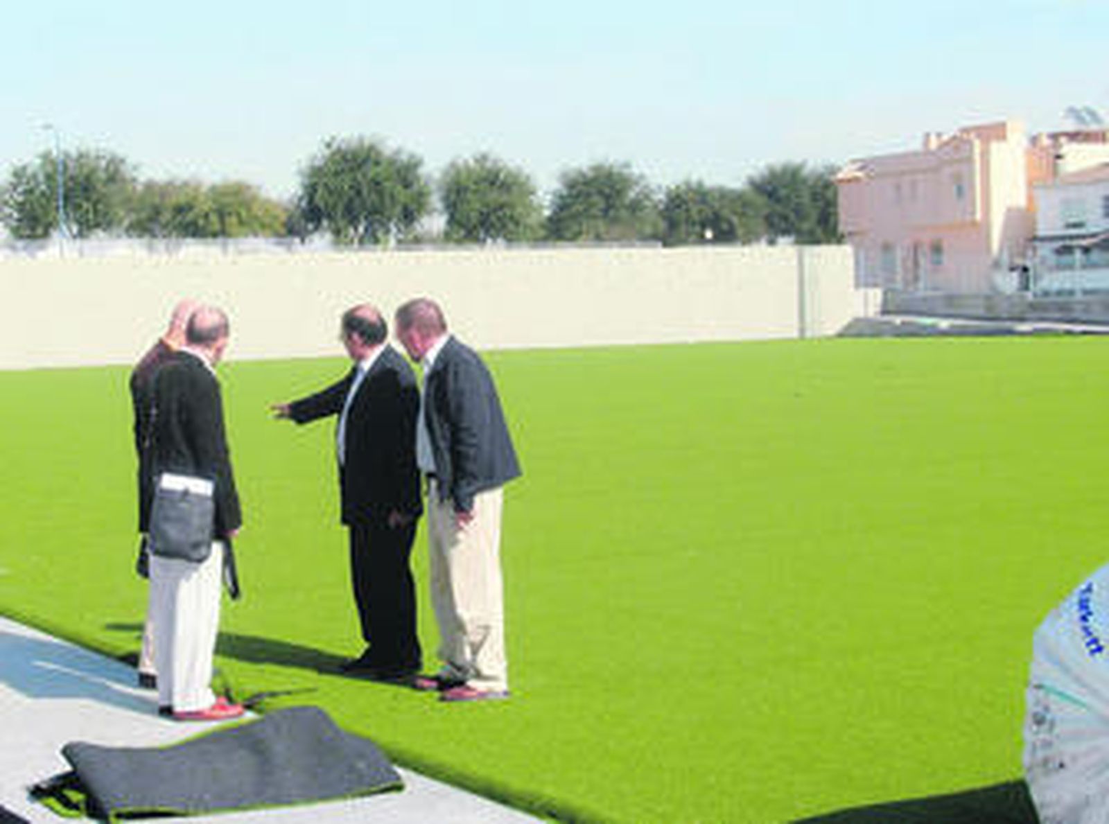 Jesús Hidalgo, gerente del Patronato, muestra a José Antonio Gil parte del césped sobre agua.