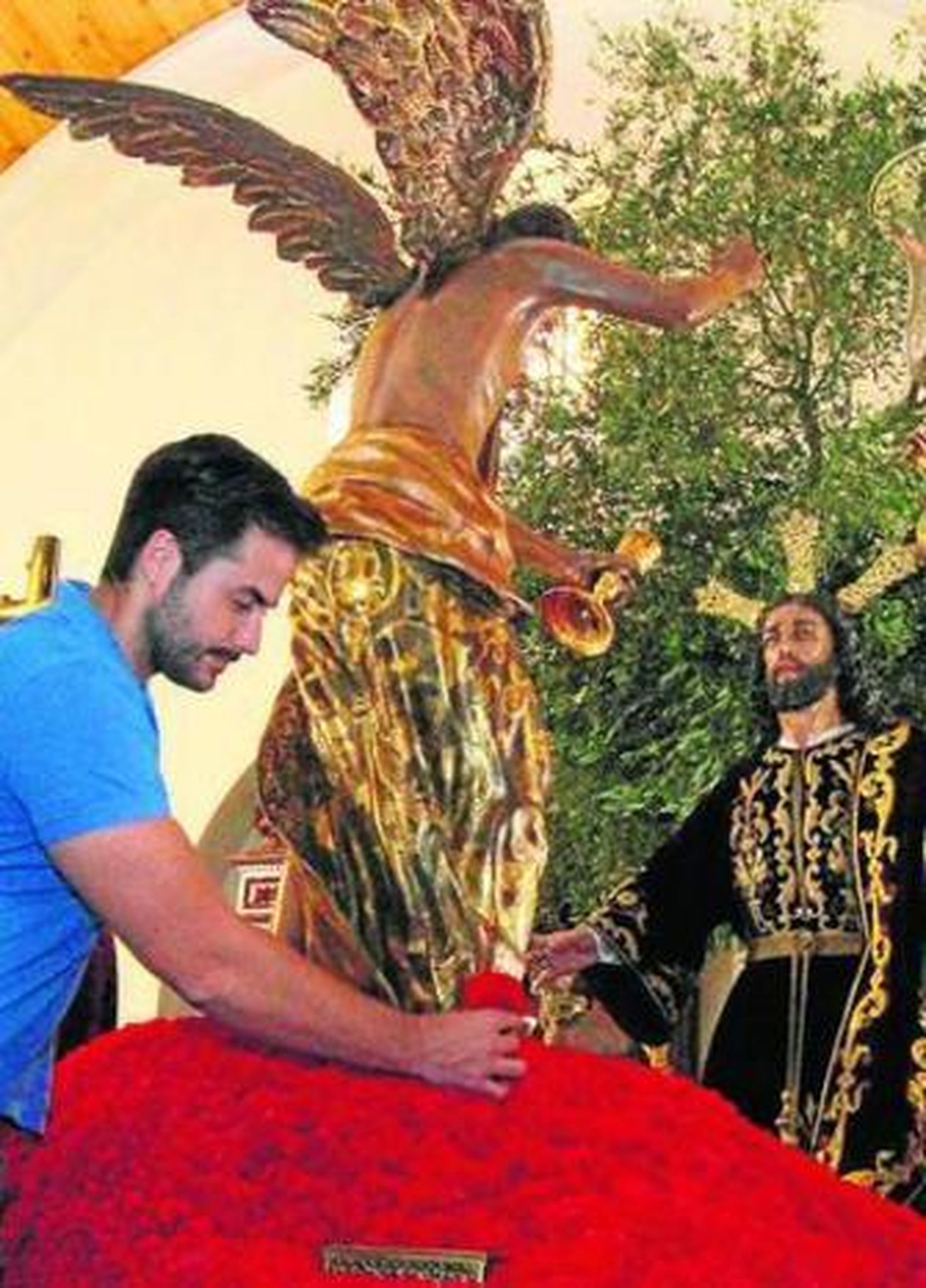 Antonio Rivera pone el monte de claveles al paso de la Oración en el Huerto. Besacinta de la Soledad y tres jóvenes ante el Cristo del Cautivo.