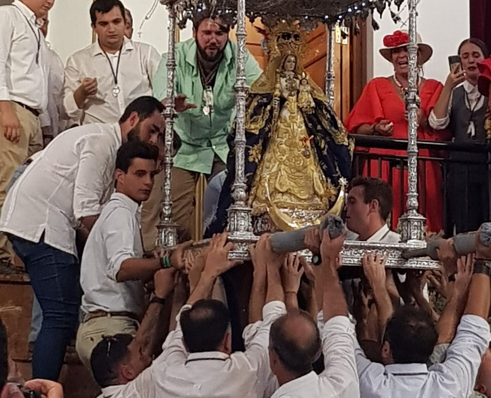 Vecinos bajando del altar la imagen de Nuestra Señora de Las Montañas, en su santuario.
