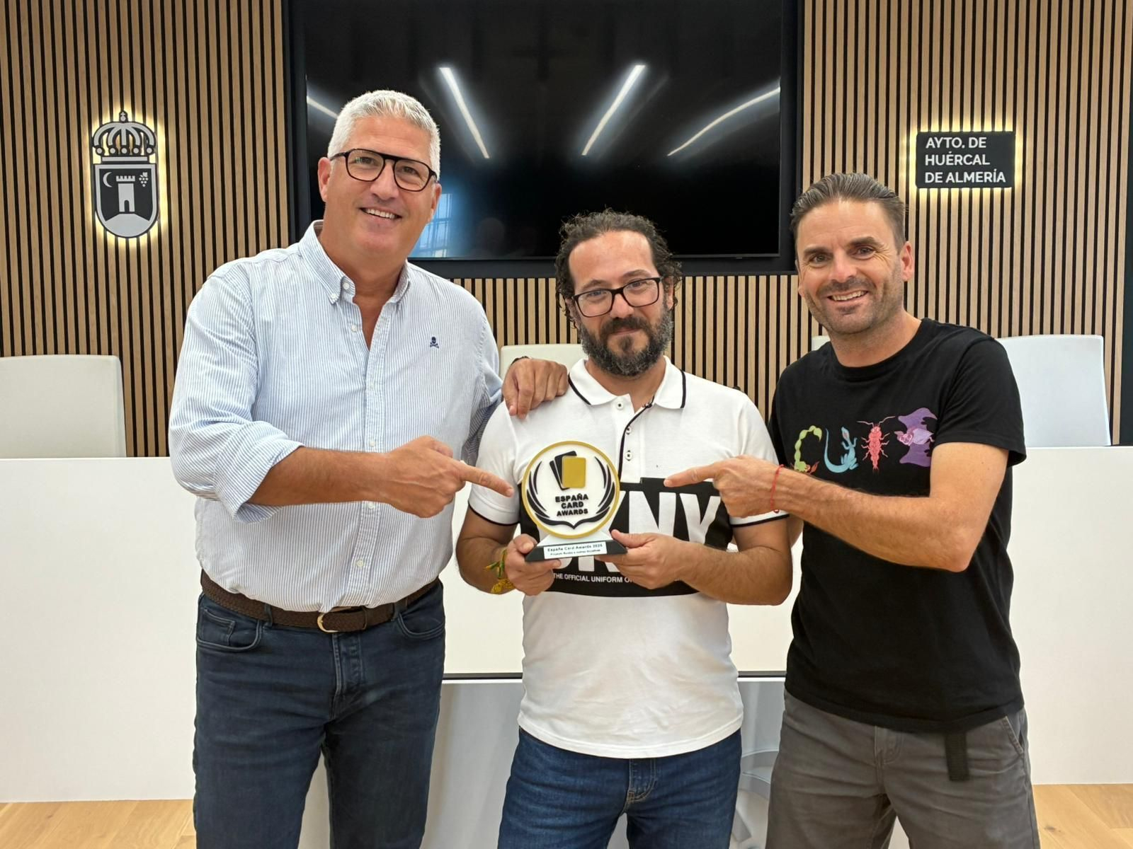 El alcalde y los organizadores muestran el premio.