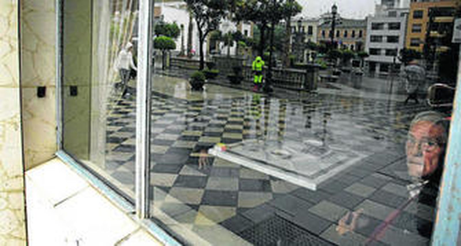 Un hombre en el Casino de Algeciras durante el apagón. En los cristales, el reflejo de la plaza Alta.
