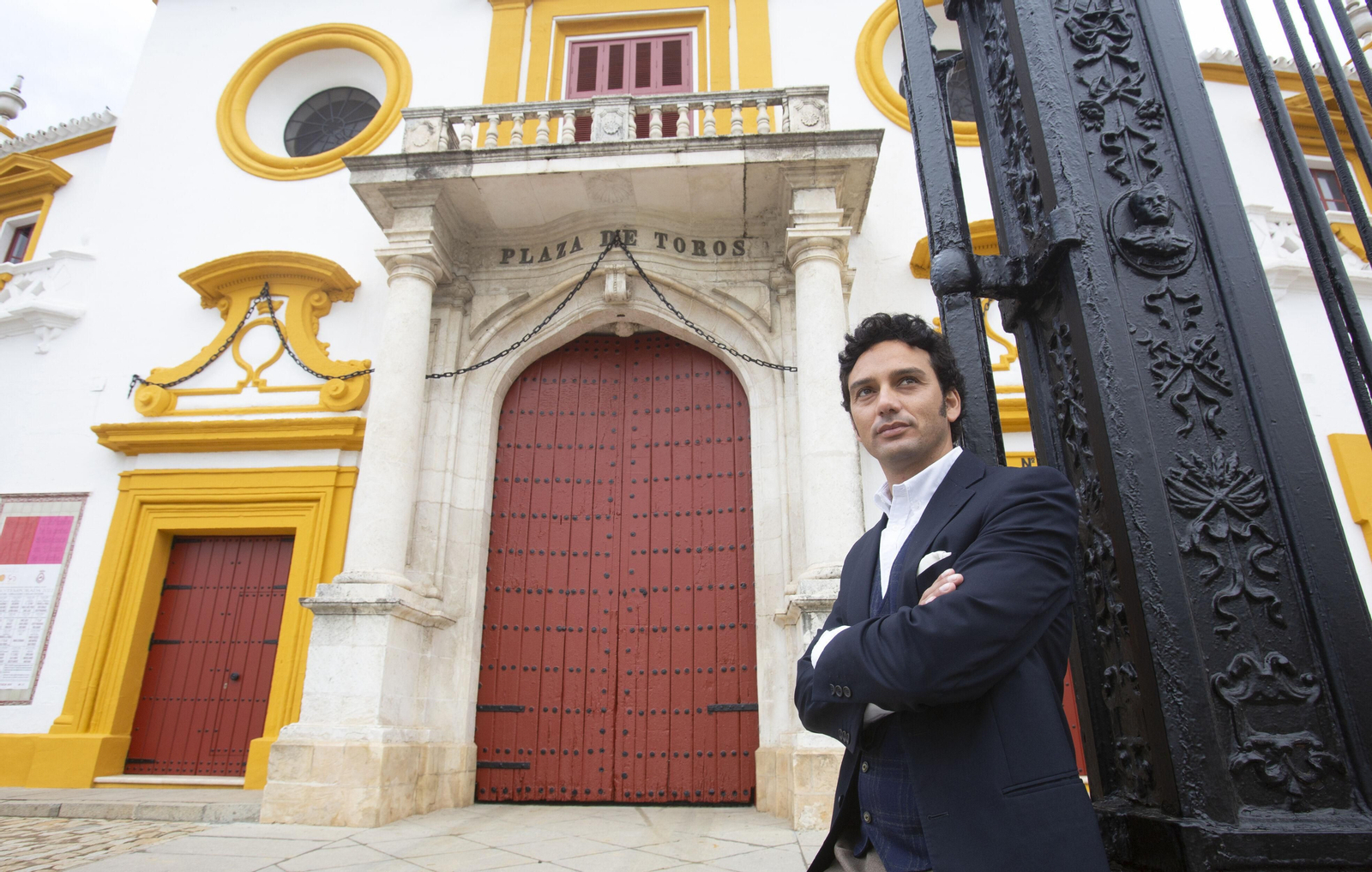Oliva Soto apoyado en la reja de la plaza de toros de la Maestranza.