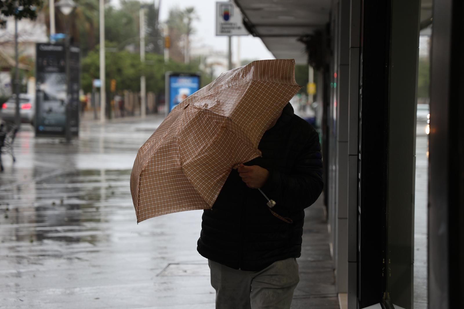 Un hombre bajo el paraguas este sábado en Huelva.