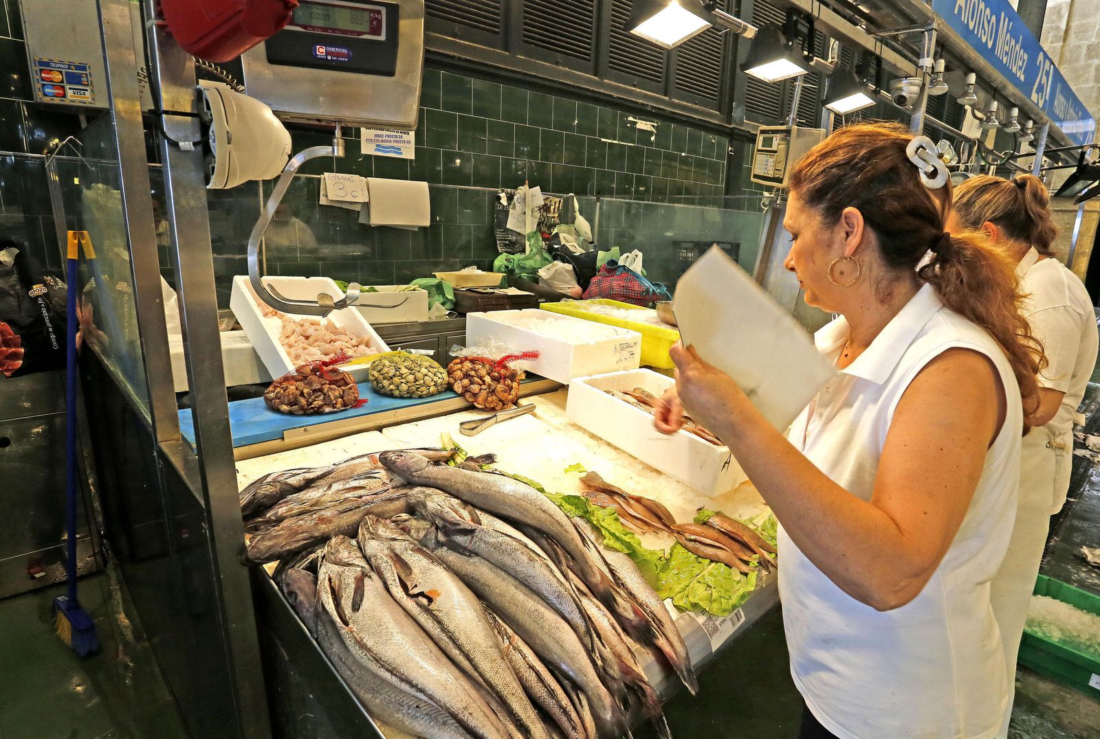 Una pescadera se abanica a última hora de la mañana de ayer.