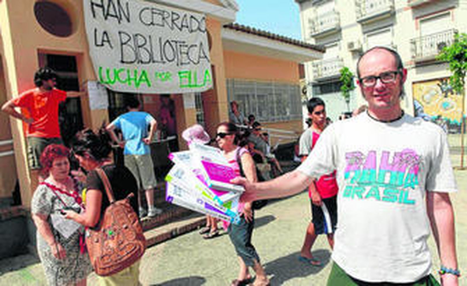 Un vecino muestra los libros que va a intercambiar en la plaza.