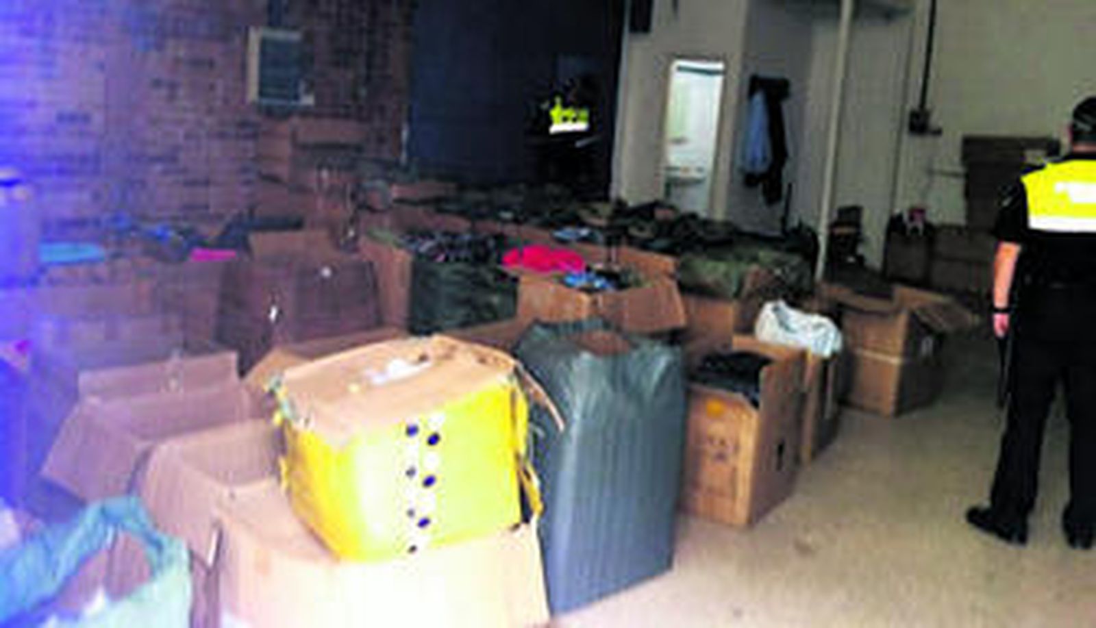 LA OPERACIÓN CANCELA, EN IMÁGENES. Sobre estas líneas, un momento del registro de la Policía Local en las naves del polígono Store. En las imágenes pequeñas, los perfumes intervenidos, cuyos códigos de barras fueron leídos como originales por los escáneres de unos grandes almacenes.