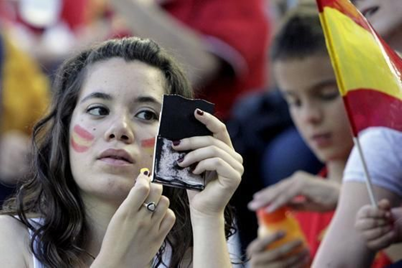 Una aficionada se pinta la cara con los colores de España. / EFE